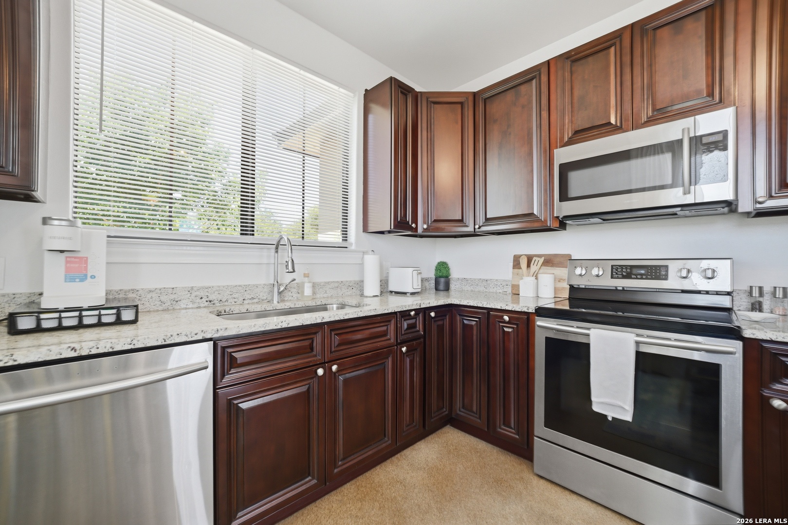 10042 Rafter S Trail Helotes, TX 78023 - Photo 62 of 69 a kitchen with stainless steel appliances granite countertop a stove sink microwave and cabinets