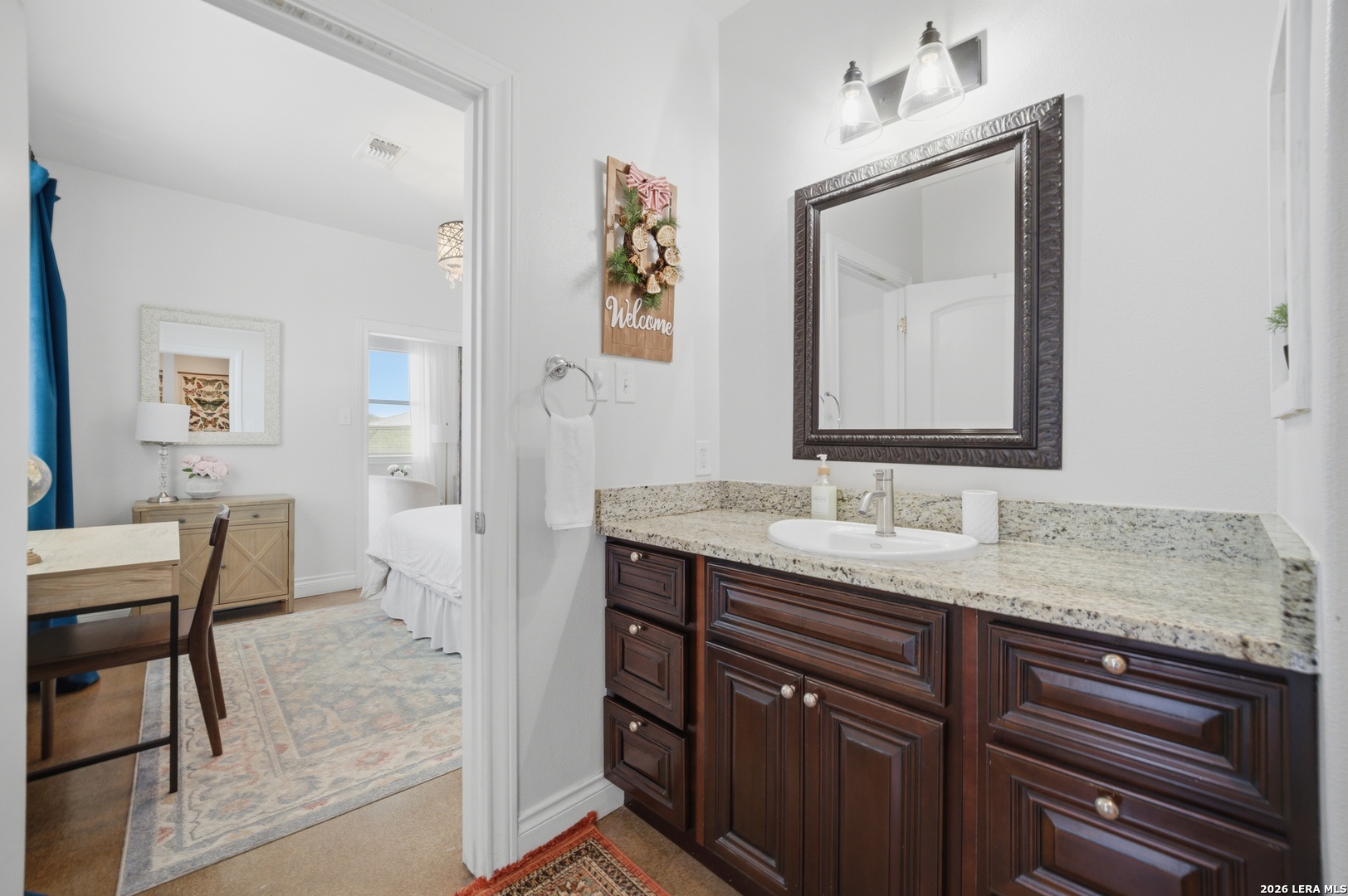 10042 Rafter S Trail Helotes, TX 78023 - Photo 65 of 69 a en suite bathroom with a granite countertop sink and a mirror
