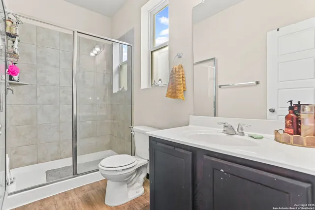 a bathroom with a sink a toilet and shower