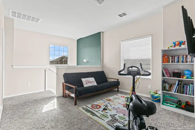 a living room with furniture and a book shelf