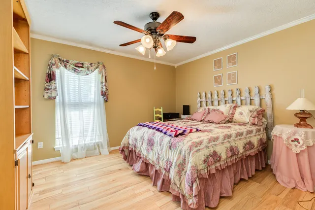 a bedroom with a bed and a ceiling fan