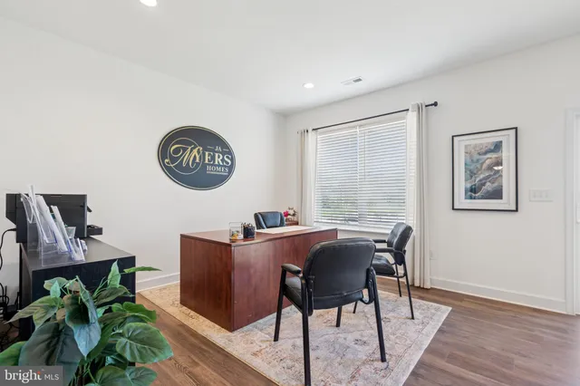 a view of a work space with furniture and wooden floor