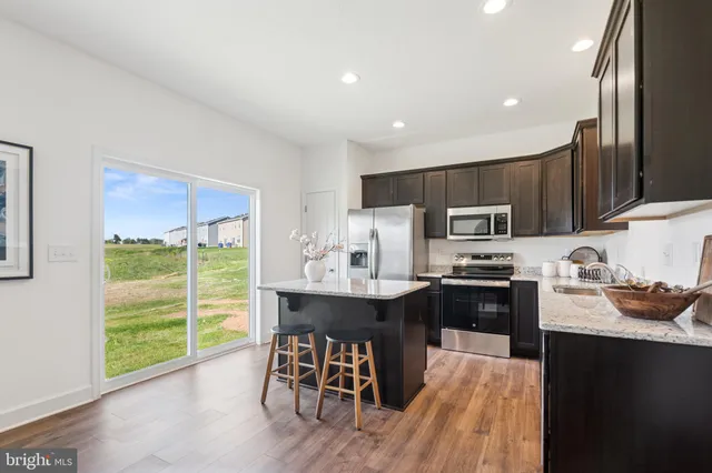 a kitchen with kitchen island granite countertop a sink counter top space appliances and cabinets