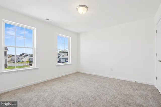 an empty room with windows and painted walls