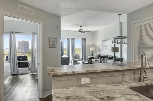 a view of kitchen island with granite countertop a sink and a counter top space