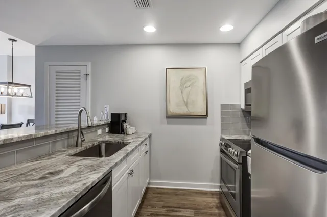 a kitchen that has a sink a refrigerator and a stove top oven