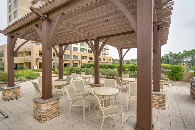 a view of a roof deck with table and chairs a barbeque with wooden floor and fence