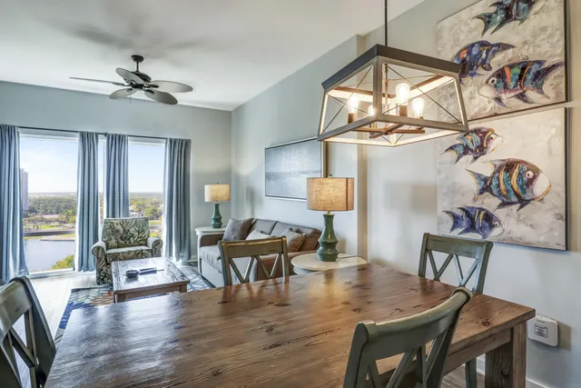 a view of a livingroom and dining room with wooden floor a chandelier