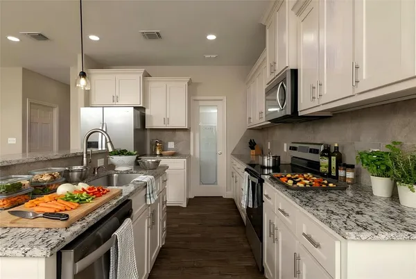 a kitchen with stainless steel appliances granite countertop a stove a sink and a refrigerator