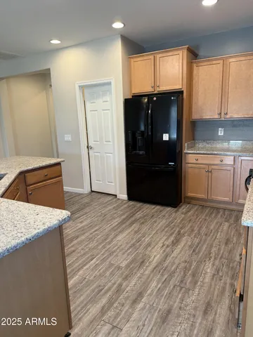 a kitchen with granite countertop a refrigerator sink and cabinets