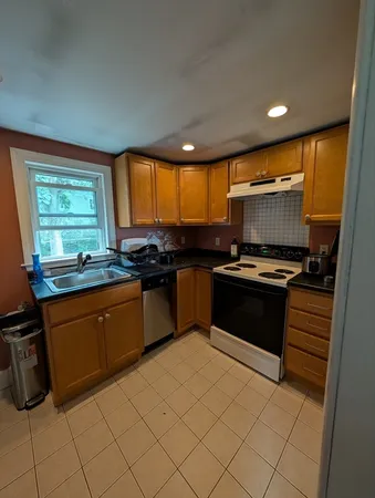 a kitchen with granite countertop a stove a sink and a microwave