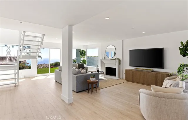 a large white kitchen with a sink and chairs