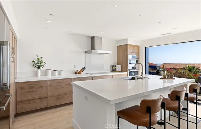 a kitchen with kitchen island a sink stainless steel appliances and cabinets