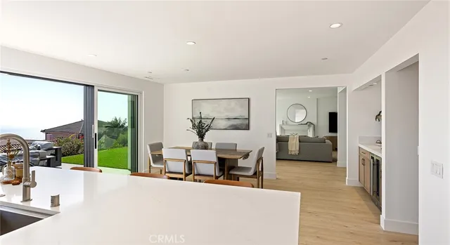 a kitchen with a sink a refrigerator and chairs