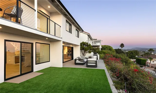 a living room with furniture a fireplace and a floor to ceiling window