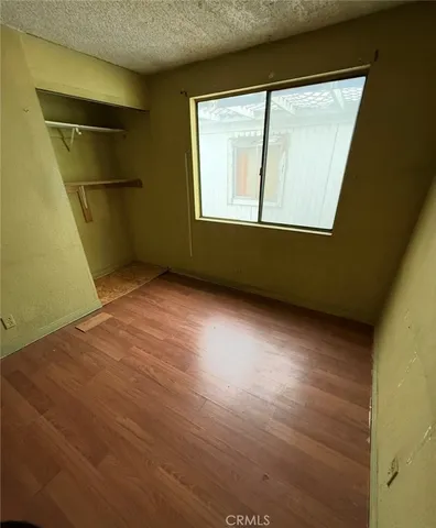 a view of empty room with window and refrigerator