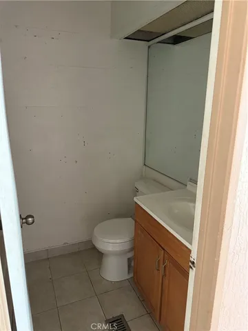 a bathroom with a granite countertop toilet and a sink