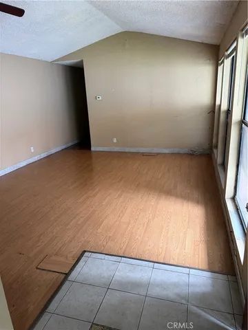 en empty room with wooden floor and windows