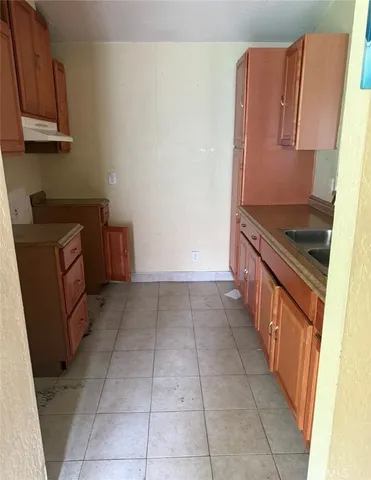 a kitchen with granite countertop a cabinets and a stove top oven