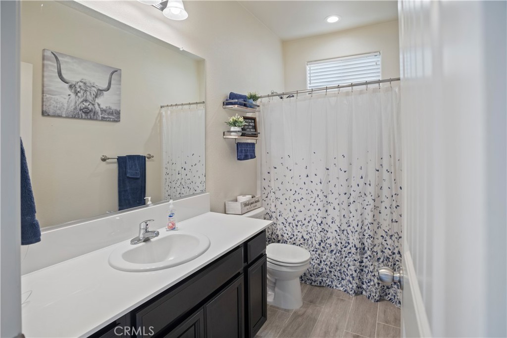 4440 Lindsey Lane Merced, CA 95348 - Photo 13 of 23 a bathroom with a toilet sink and mirror