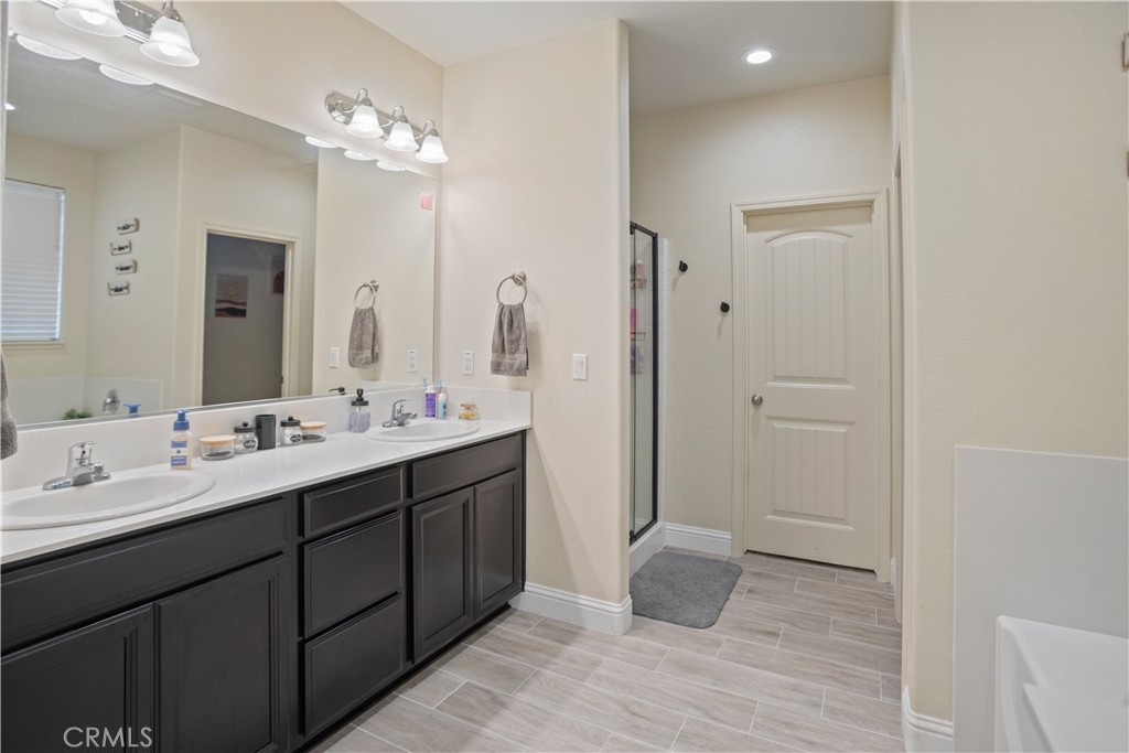 4440 Lindsey Lane Merced, CA 95348 - Photo 20 of 23 a bathroom with a double vanity sink and mirror