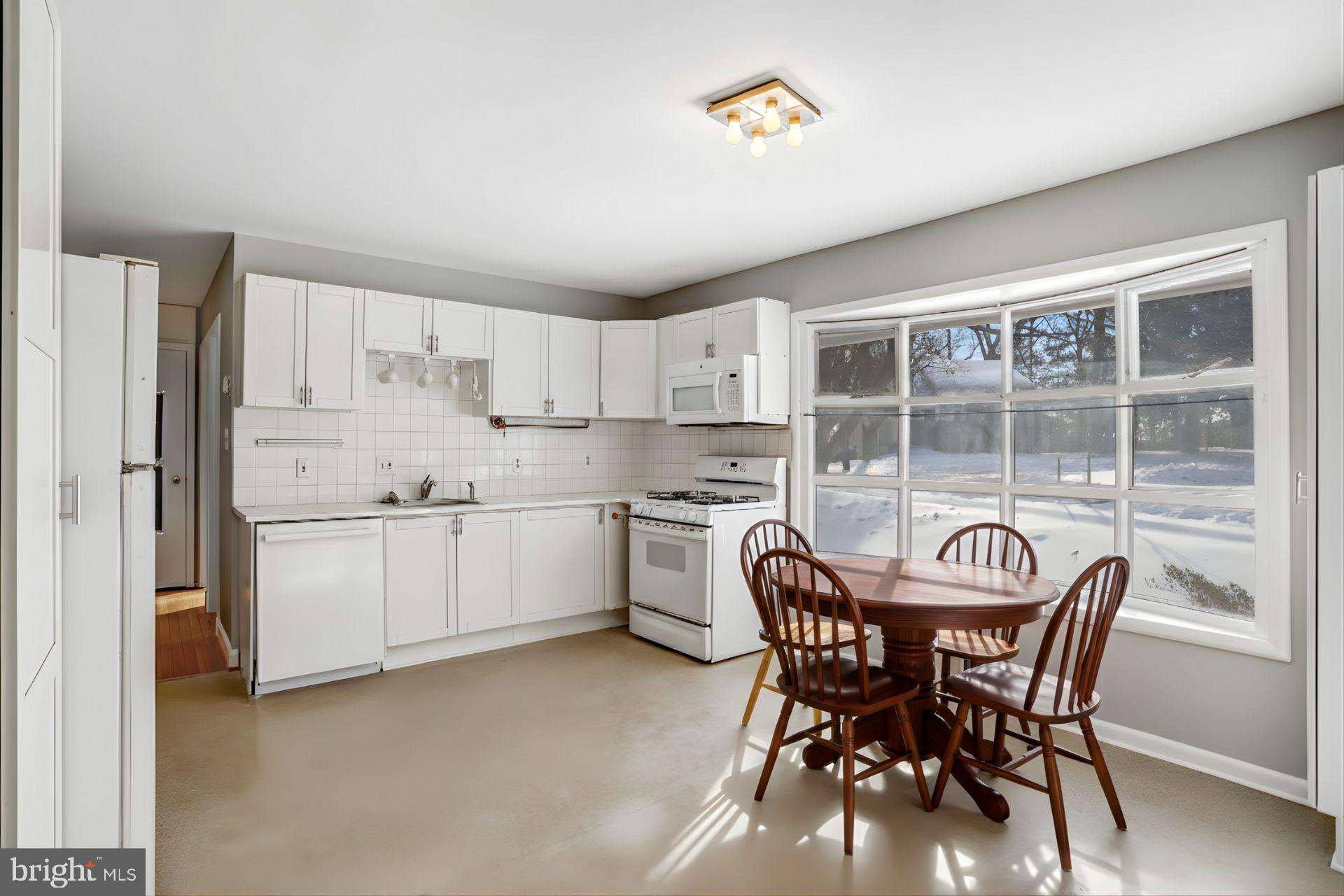 841 Bowie Road Rockville, MD 20852 - Photo 4 of 18 a kitchen with a table chairs a sink refrigerator and cabinets