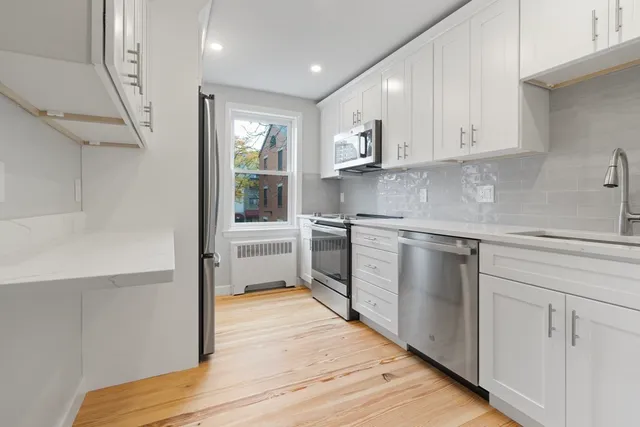 a kitchen with white cabinets and white appliances
