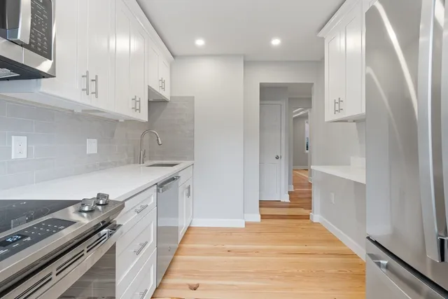 a kitchen with granite countertop white cabinets and appliances