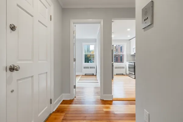 a view of a hallway with wooden floor and glass door