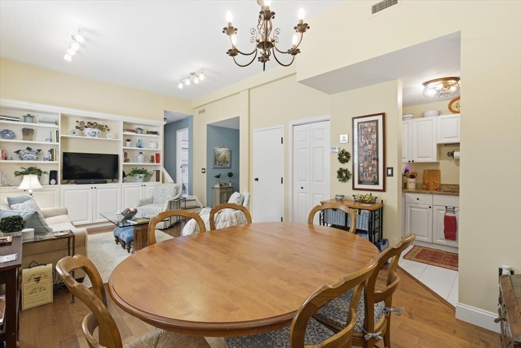65 Glen Road, Unit H1 Brookline, MA 02445 - Photo 11 of 39 a room with stainless steel appliances a dining table chairs and a chandelier
