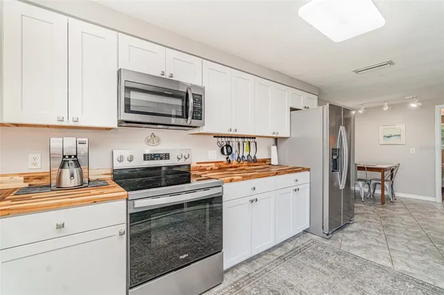 a kitchen with stainless steel appliances granite countertop a stove a sink and a refrigerator