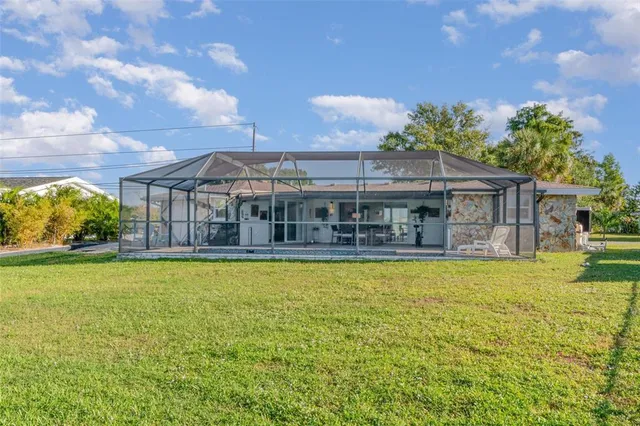 a view of a house with a swimming pool and a yard