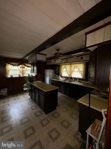 a living room with furniture a flat screen tv and kitchen view