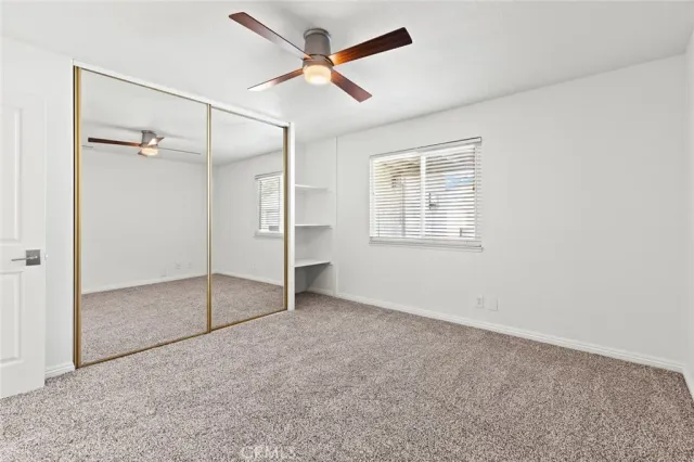 an empty room with closet and windows