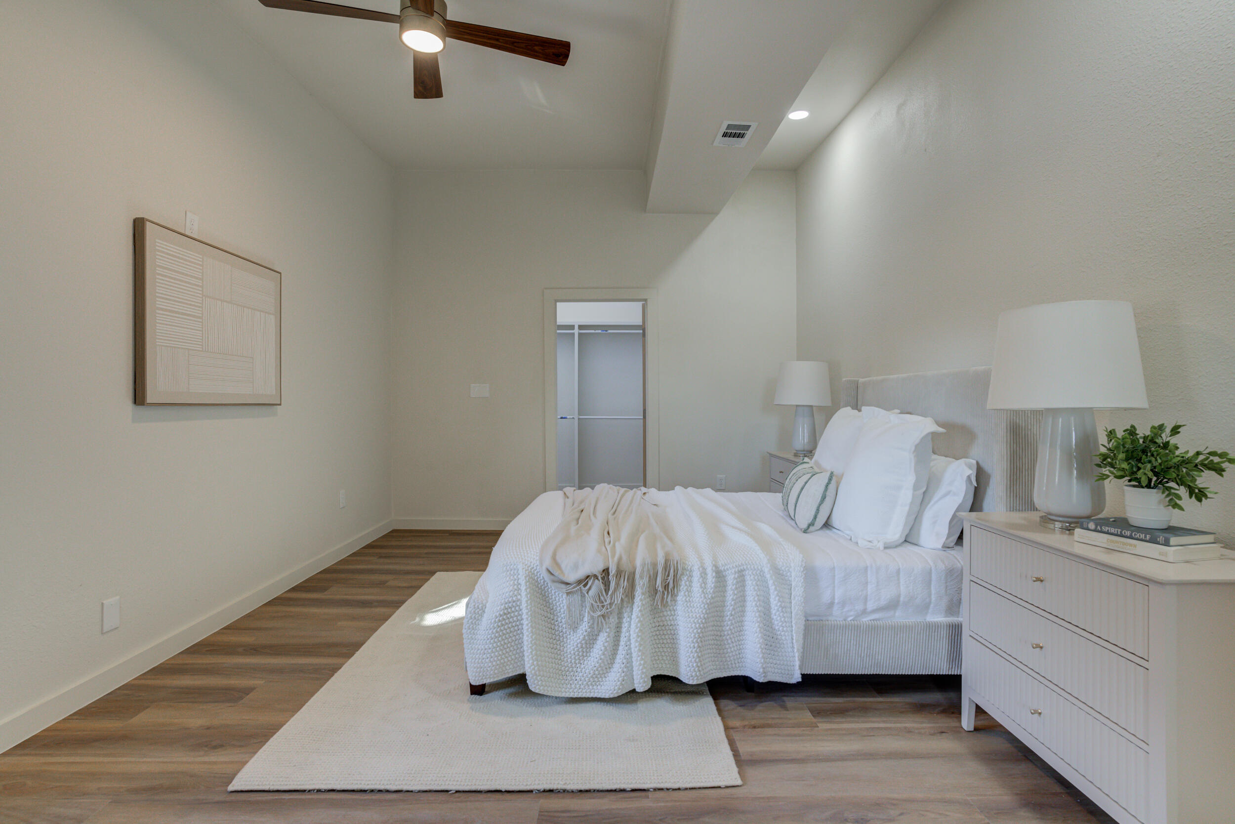 2218 58th Street Lubbock, TX 79412 - Photo 29 of 66 a bedroom with a bed and a potted plant