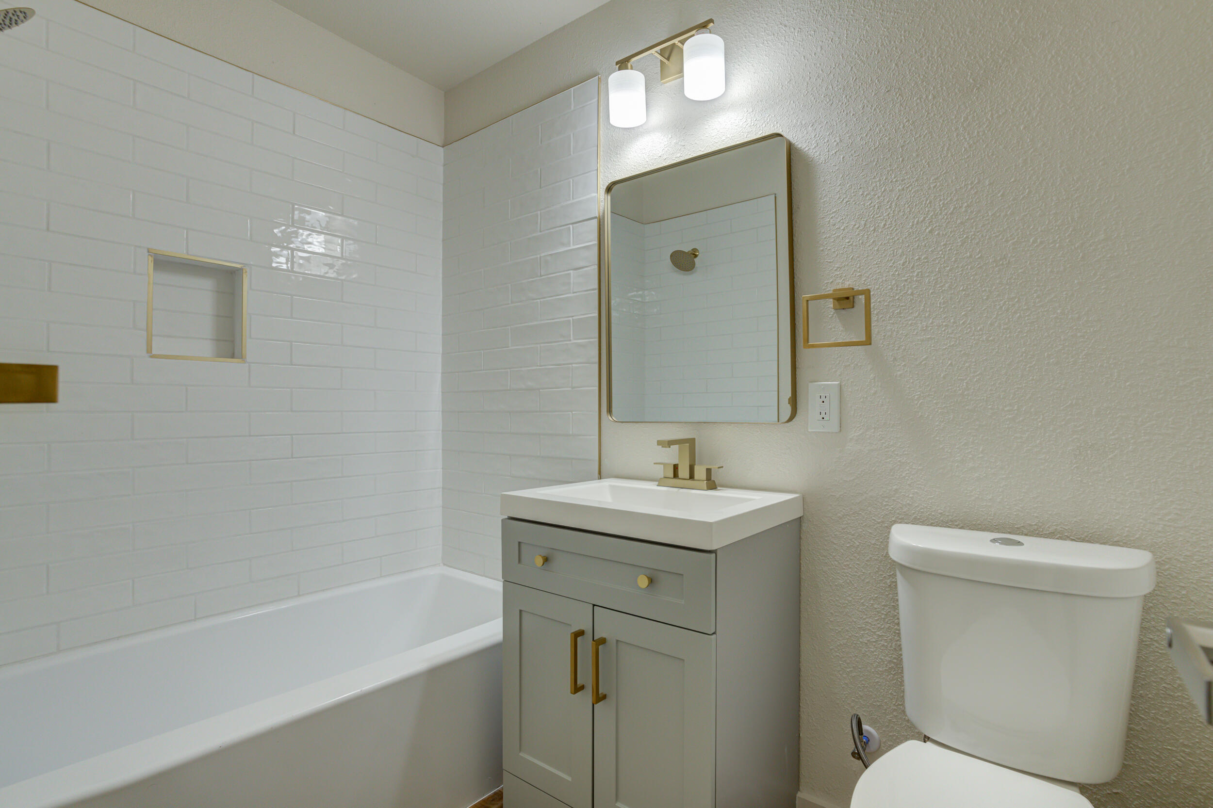 2218 58th Street Lubbock, TX 79412 - Photo 8 of 66 a bathroom with a toilet sink and mirror