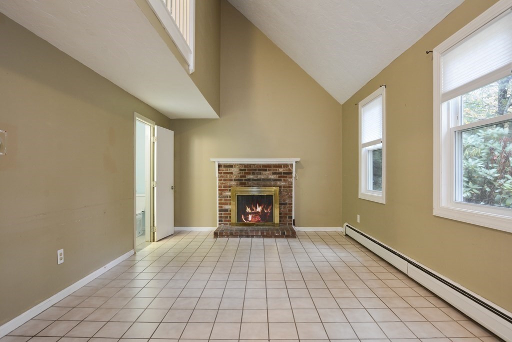 499 Skunknet Road Barnstable, MA 02632 - Photo 4 of 16 a view of an empty room with a fireplace and a window