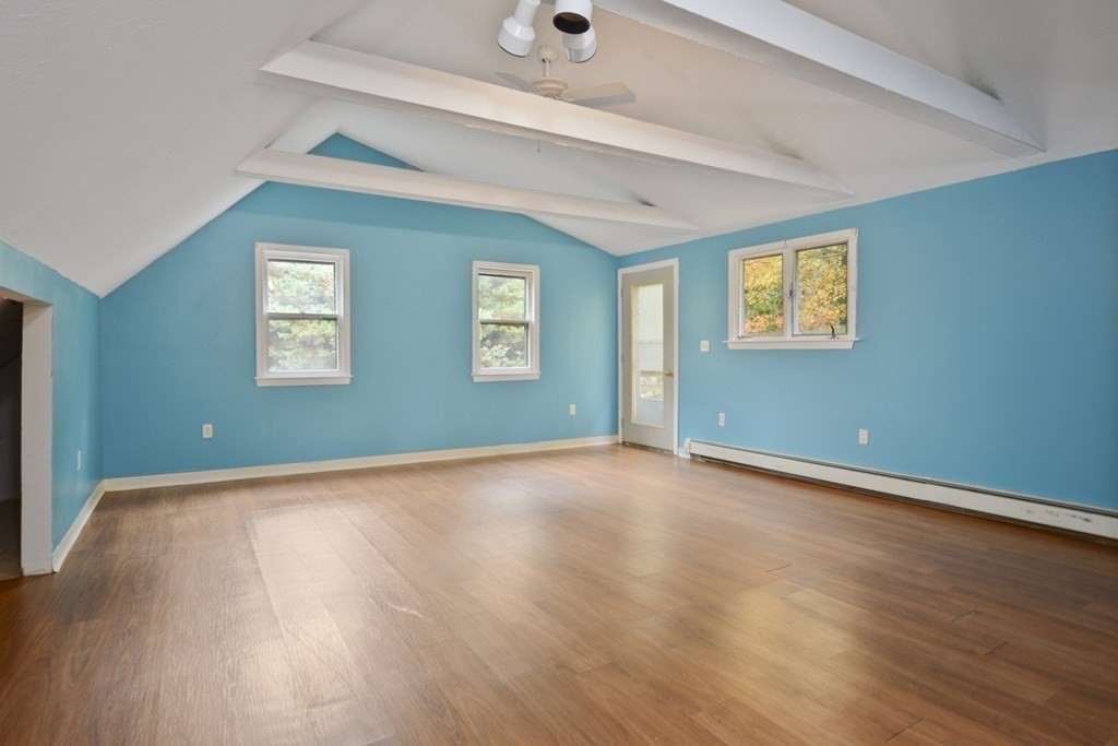 499 Skunknet Road Barnstable, MA 02632 - Photo 9 of 16 an empty room with wooden floor and windows