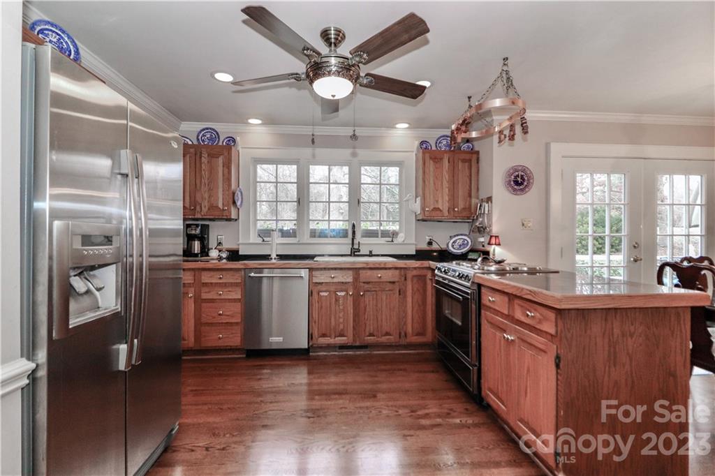 415 Westchester Road Statesville, NC 28625 - Photo 20 of 48 an open kitchen with granite countertop a refrigerator a sink dishwasher a stove and white cabinets with wooden floor