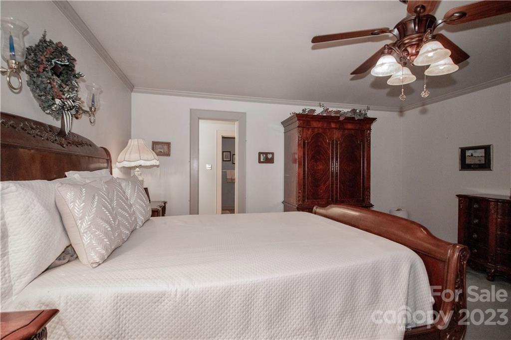 415 Westchester Road Statesville, NC 28625 - Photo 31 of 48 a bedroom with a large bed and a chandelier