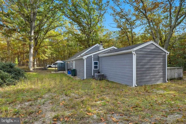a view of a house with large tree and wooden fence