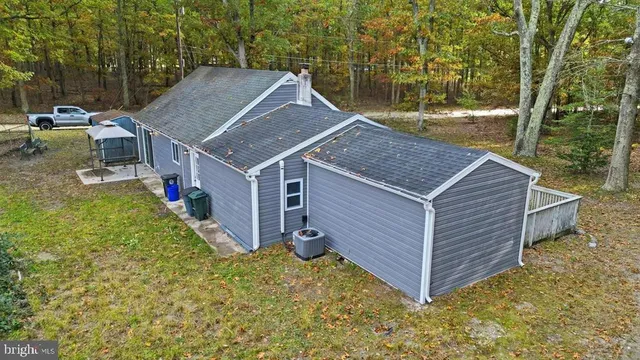 a view of a house with a yard and large tree