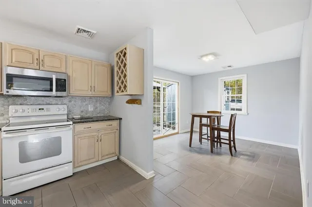a kitchen with granite countertop cabinets stainless steel appliances and dining table