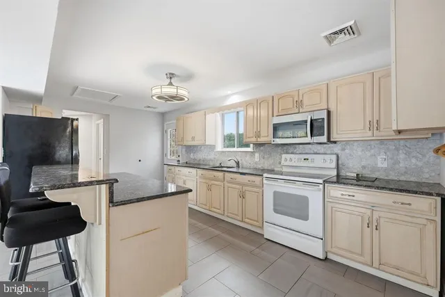 a kitchen with white cabinets and black appliances