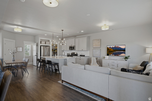 69 South Rio Grand Avenue Farmington, UT 84025 - Photo 23 of 41 Open-concept living area featuring wood-finish flooring, recessed lighting, and a kitchen with white cabinetry