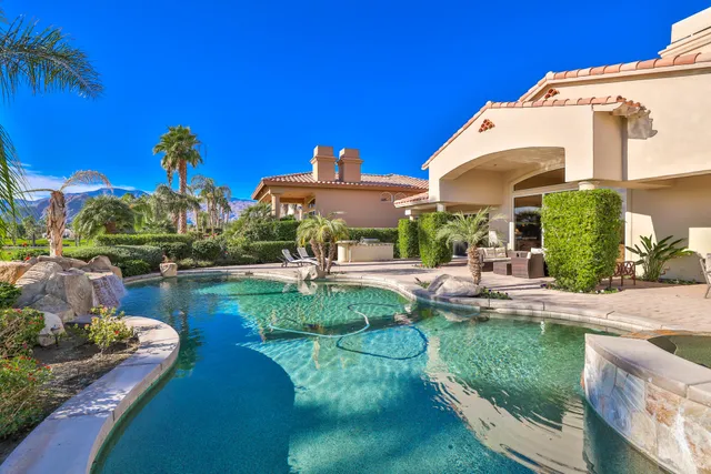 a view of a house with pool and chairs