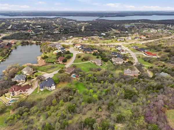 an aerial view of residential houses with outdoor space and trees