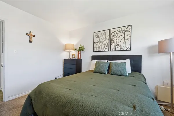 a large bed sitting in a bedroom next to a lamp