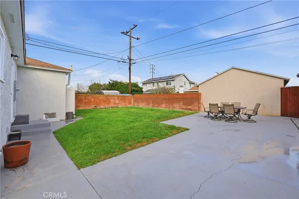 a view of a backyard with table and chairs a fire pit