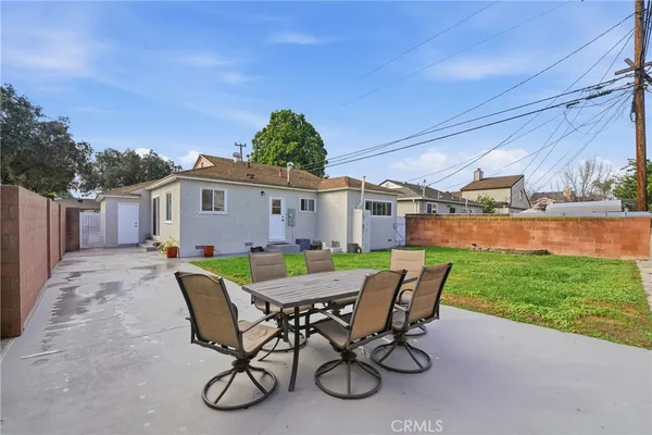 a view of a house with backyard and sitting area